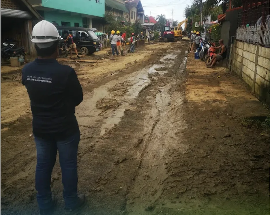 A man wearing a hard hat overseeing road reconstruction as CLI demonstrates its commitment to long-term community recovery in Cebu