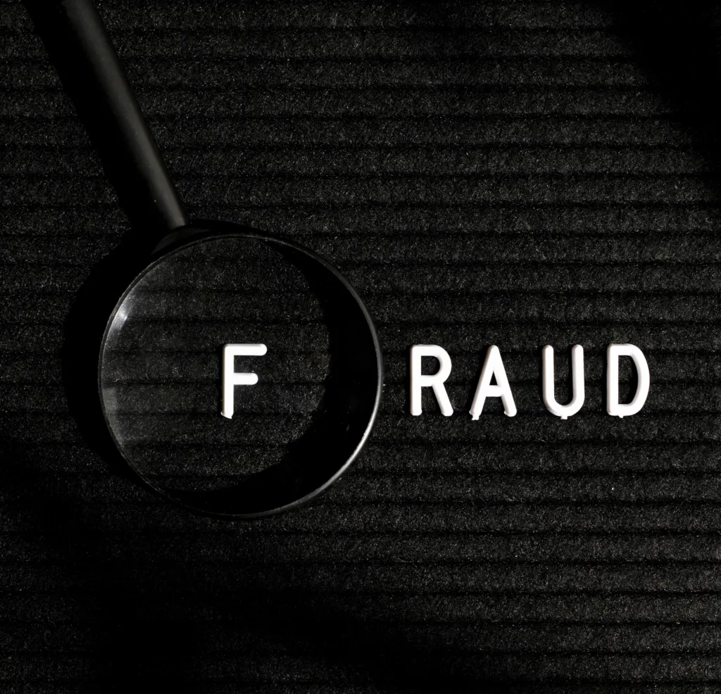 Fraud word with letter in a magnifying glass top view